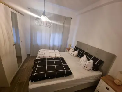 a bedroom with a bed with black and white sheets at Black Forest House in Banja Luka