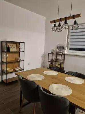a dining room with a wooden table and chairs at Black Forest House in Banja Luka