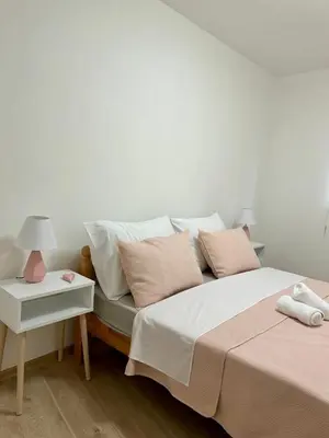 a bedroom with two beds and a table with a lamp at Jelena in Jajce