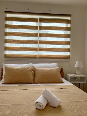 a white towel laying on a bed in front of a window at Jelena in Jajce
