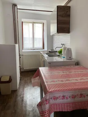a small kitchen with a table and a sink at Apartman ''Trg'' in Tuzla