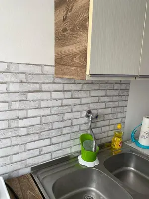 a kitchen sink with a green cup and a faucet at Apartman ''Trg'' in Tuzla