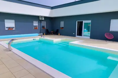 a large swimming pool in a room with blue walls at Villa De Luxe Infinity in Bihać