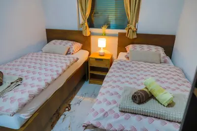 two twin beds in a room with a window at Villa De Luxe Infinity in Bihać