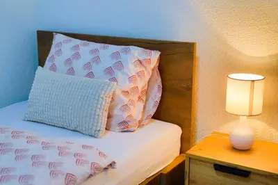 a bed with a pillow and a lamp on a table at Villa De Luxe Infinity in Bihać