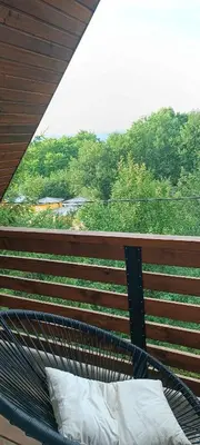 a bed on a balcony with a view of trees at Pyramid Holiday House in Visoko