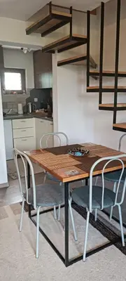 a wooden table and chairs in a kitchen at Pyramid Holiday House in Visoko