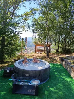 two men in a hot tub in the grass at Oaza Mira - Sakina Pecina in Fojnica