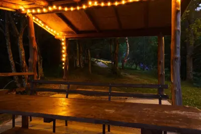 a wooden bench under a gazebo with lights at Oaza Mira - Sakina Pecina in Fojnica