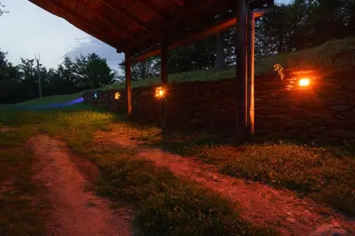 a dirt road next to a stone building at night at Oaza Mira - Sakina Pecina in Fojnica