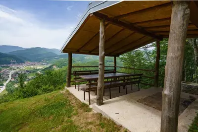 a wooden pavilion with benches on top of a hill at Oaza Mira - Sakina Pecina in Fojnica