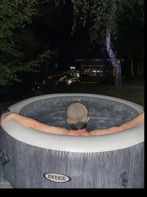 a person in a pool of water with a hat in it at Oaza Mira - Sakina Pecina in Fojnica