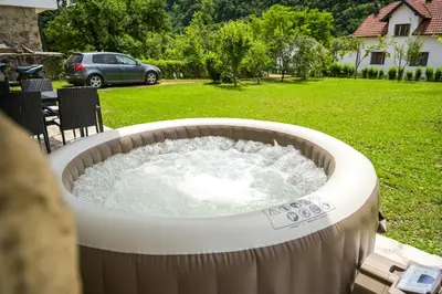 a large hot tub with water in a yard at Apartman Kiko in Jajce