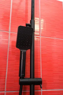 a black object is standing in front of a red wall at Apartman Kiko in Jajce