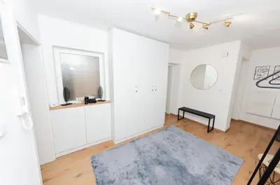 a living room with white walls and a blue rug at Apartment Center Korzo in Bihać