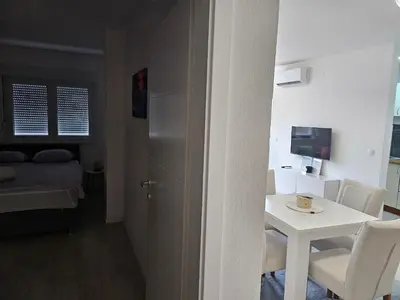 a small room with a small table and a room with a bed at Apartman Aura in Bosanska Gradiška