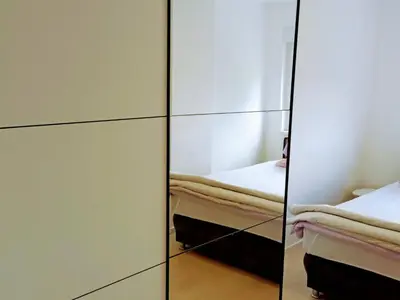 a bedroom with a mirror and a bed in a room at Apartman Aura in Bosanska Gradiška