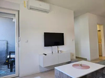 a living room with a flat screen tv on a wall at Apartman Aura in Bosanska Gradiška