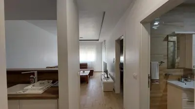 a large white bathroom with a sink and a desk at SMART LUX Apartment in Modriča