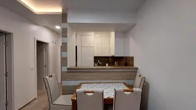 a dining room with a table and chairs and a kitchen at SMART LUX Apartment in Modriča