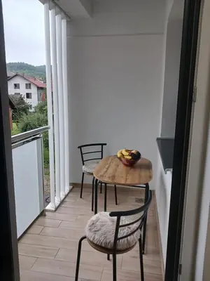 a balcony with two chairs and a table with fruit on it at SMART LUX Apartment in Modriča