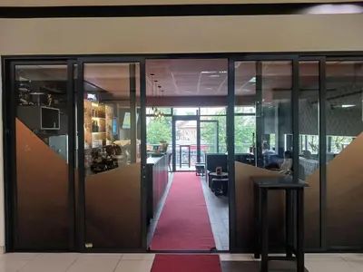 an office lobby with glass doors and a red carpet at SMART LUX Apartment in Modriča