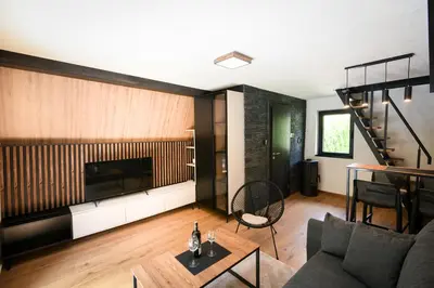 a living room with a couch and a tv at Vikendica Villa Natasa in Banja Luka