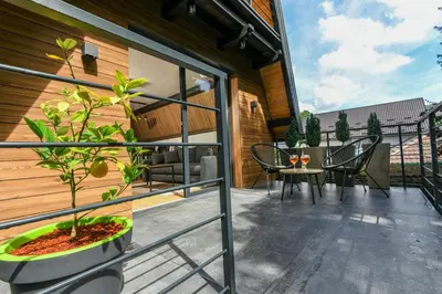 a balcony with a table and chairs and a plant at Vikendica Villa Natasa in Banja Luka