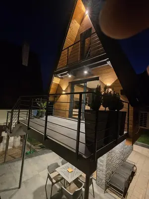 a house with a balcony with a table and chairs at Vikendica Villa Natasa in Banja Luka