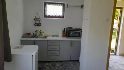 a small kitchen with a sink and a microwave at Vikendica Davidović in Landeke