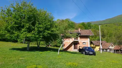 a car parked in front of a house in a field at Vikendica Davidović in Landeke