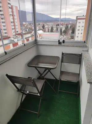 two chairs and a table in a room with windows at Asya Art in Bihać