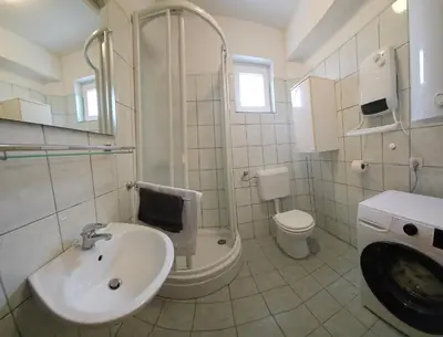 a bathroom with a sink and a shower and a toilet at Livanjsko Polje Cottage #14 in Lusnić
