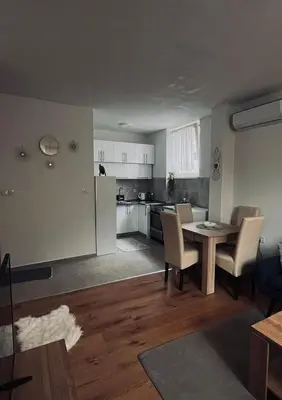 a kitchen and a living room with a table and chairs at Travnik Nostalgia Apartment in Travnik
