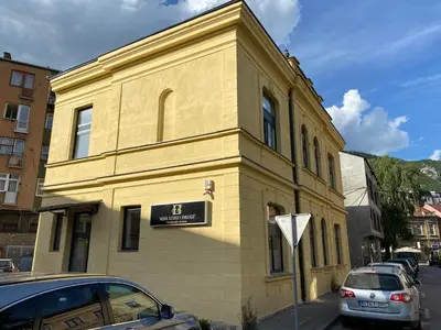 a yellow building with a sign on the side of it at Travnik Nostalgia Apartment in Travnik
