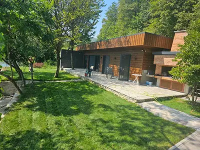 a wooden house with a lawn in front of it at Villa Vigo in Bosanska Krupa