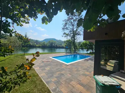 a swimming pool with a view of a lake at Villa Vigo in Bosanska Krupa