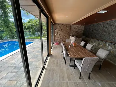 a dining room with a wooden table and chairs at Villa Vigo in Bosanska Krupa