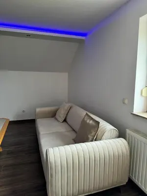 a white couch in a living room with a blue light at Ivan in Livno