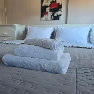 a pile of towels sitting on top of a bed at Alex Bl in Banja Luka
