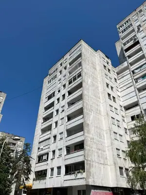 a tall white building with a blue sky behind it at Alex Bl in Banja Luka