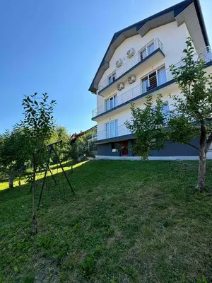 a building with a tree in front of it at Apartment BORICI in Bihać