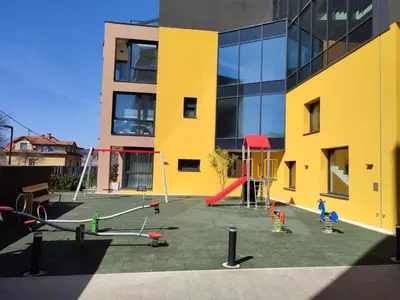 a playground in front of a building with children playing at Banja Apartman in Tuzla
