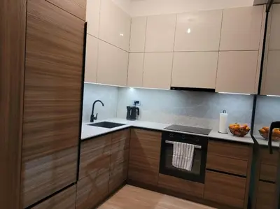 a kitchen with wooden cabinets and a sink and a stove at Banja Apartman in Tuzla