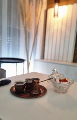 a tea pot and two cups on a table at Banja Apartman in Tuzla