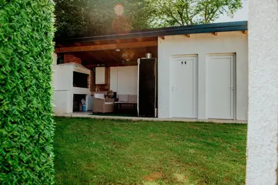 a house with a garage with a green hedge at Kuća za odmor Vučjak in Bihać