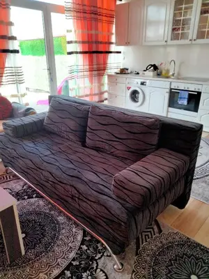 a couch with a blanket on it in a living room at Kumalic 2 in Sanski most