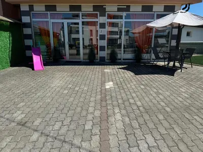 a patio with a table and an umbrella in front of a building at Kumalic 2 in Sanski most