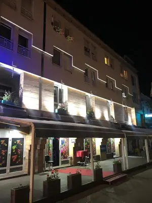 a building with a lit up facade at night at Apartment Stari Grad Korzo Tuzla in Tuzla