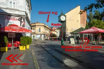 a city street with a clock on a building at Apartment Stari Grad Korzo Tuzla in Tuzla